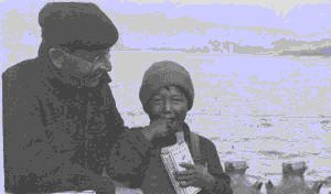 Image: Crewman with Eskimo [Inuk] boy aboard. Boy is eating Cracker Jacks