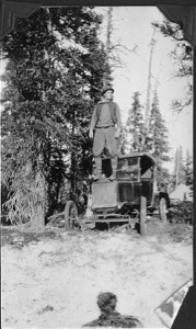 Image of William Jennison standing on hood of snowmobile