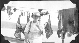 Image of Man aboard, with meat and skins hung to dry