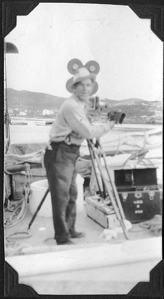 Image of ? with movie camera and equipment on deck