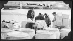 Image: Men check barrels and cartons aboard