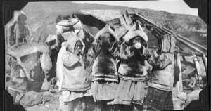 Image of Four Eskimo [Inuit] girls in furs, blowing up balloons