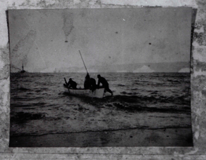 Image of Four men setting out in open boat. Icebergs and vessel  beyond  (V-14)