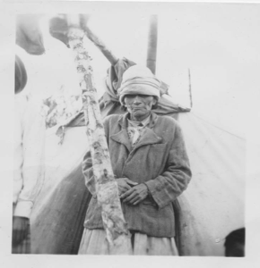 Image of Blind Innu woman by tent [Tshuteu (Agnes) Rich]