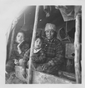 Image of Innu mother and children in tent doorway [Akat (Agathe) Rich and Shaiet (Janet) Rich (girl on left)]