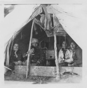 Image of Innu mother and children in tent [Shaiet (Janet) Rich (girl on left,) Akat (Agathe) Rich, Pinamen (Philomena) Katchinak (white jacket)]