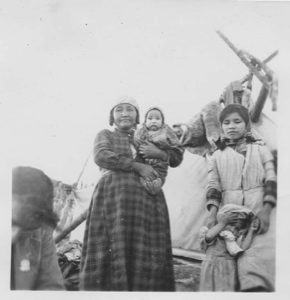 Image of Innu mothers and children by tent [Shenish Pasteen (foreground), Manishan (Mary Jane) Pasteen, Shanut (Janet) Pasteen, Tshmish (James) Pasteen, Miniskuess Pasteen]