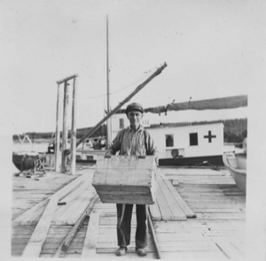 Image: Bob Best on dock, carrying crate