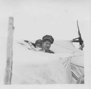 Image: Two Indian [Innu] boys wearing sailing caps look out of tent