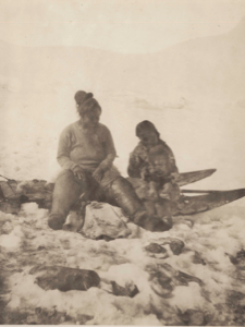 Image of Nelle-ka-tee-ah at Igloodahouny [. and second woman with baby, sitting on sledge]