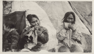 Image: Two Inuit women chewing skins, by their tupik