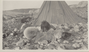 Image of Inuit boy lying on furs, by tupik