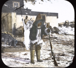 Image of Ah-na-we holding rifle and arctic hare by Borup Lodge
