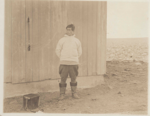 Image of Knud Rasmussed standing beside P. Freuchen's house, Thule, North Star Bay
