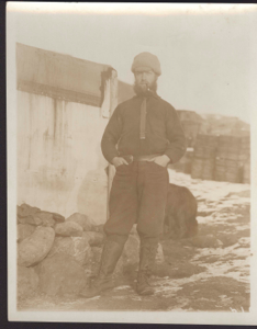 Image of Expedition member  with pipe. Many crates beyond
