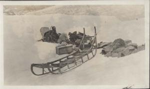 Image: Maurice Tanquary sitting by sledge and supplies
