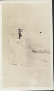 Image: Inuit(?) man on snow mound, using telescope