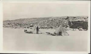 Image: Jot Small with rifle by two tupiks, and sledges