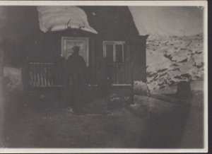 Image: Man standing on steps of frame house