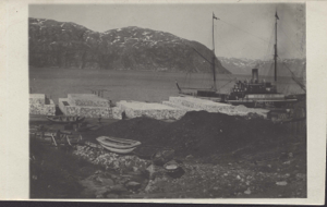 Image of Industrial site at water's edge. HANS EGEDE tied up. Small boats, hauled.