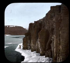 Image: Two Inuit on ice foot at base of Guillimot cliffs