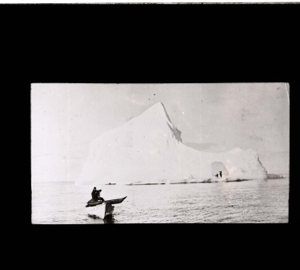 Image of Kayak on dory; 2nd kayak and iceberg beyond