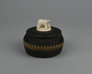 Image: black and white baleen basket with polar bear glued to flat disk as finial