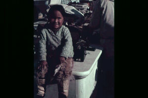 Image of Inuit girl sitting, aboard  [purple]