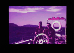 Image of Two crewmen at wheel of BOWDOIN  [purple]