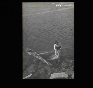 Image of Inuit holding paddle near kayak  [b&w]