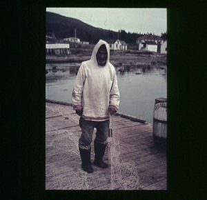 Image of Inuit man on dock with fishing net  [purple]