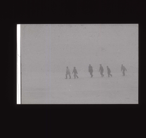Image of Six crewmen walking across snow  [b&w]