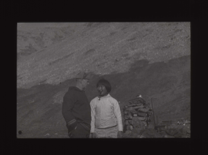 Image of Donald MacMillan and Inuit man with pipe by cairn  [b&w]