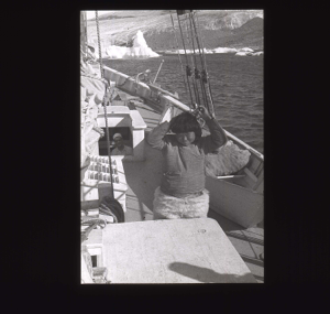 Image of Inuit man using louse catcher, aboard [b&w]