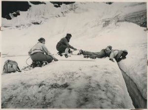 Image of Rescuers above a crevasse supporting a man by ropes