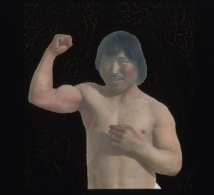 Image: Bare-chested Inuit man flexing arm muscles