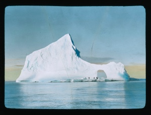 Image of Iceberg with hole. People standing on base