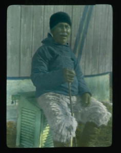 Image: Merk-to-shar, oldest man in the tribe, sittiing on louvered box ...             