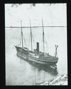 Image of The ERIK moored, two canoes at stern