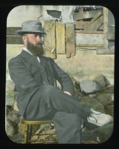 Image of Maurice Tanquary at Borup Lodge, seated outside, wearing dress suit