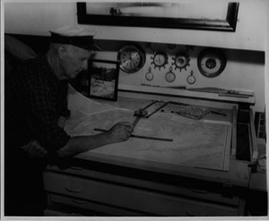Image of Donald MacMillan looking at map in the BOWDOIN's chart room