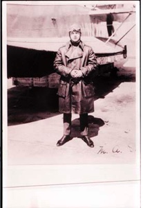 Image of Man in aviator's long coat, standing by plane