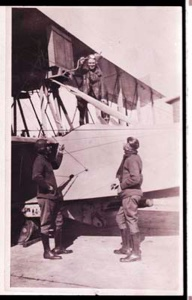 Image of Two men stand beside plane, a third is on the plane