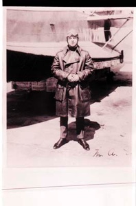 Image: Man in aviator's long coat standing by plane