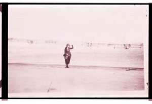 Image: Woman waving. Three (?) planes beyond