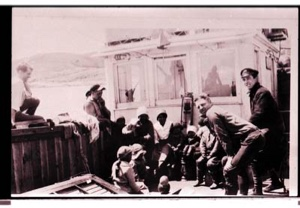 Image of Eugene McDonald with several Inuit children and adults, aboard S. S. Peary