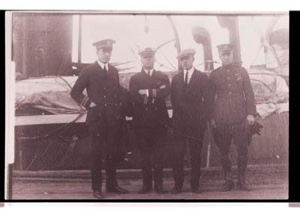 Image of Eugene McDonald, Donald MacMillan unidentified man and Richard Byrd stand on the S.S. PEARY
