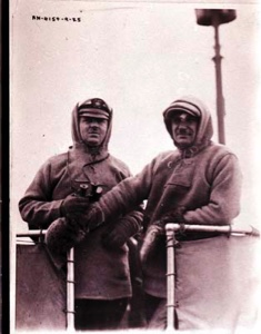 Image: Two men aboard the S.S. PEARY. One wears heavy mittens.