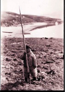 Image of Inuit boy holds a narwhal tusk