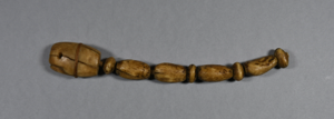 Image: set of large ivory beads strung on rawhide, splayed at end